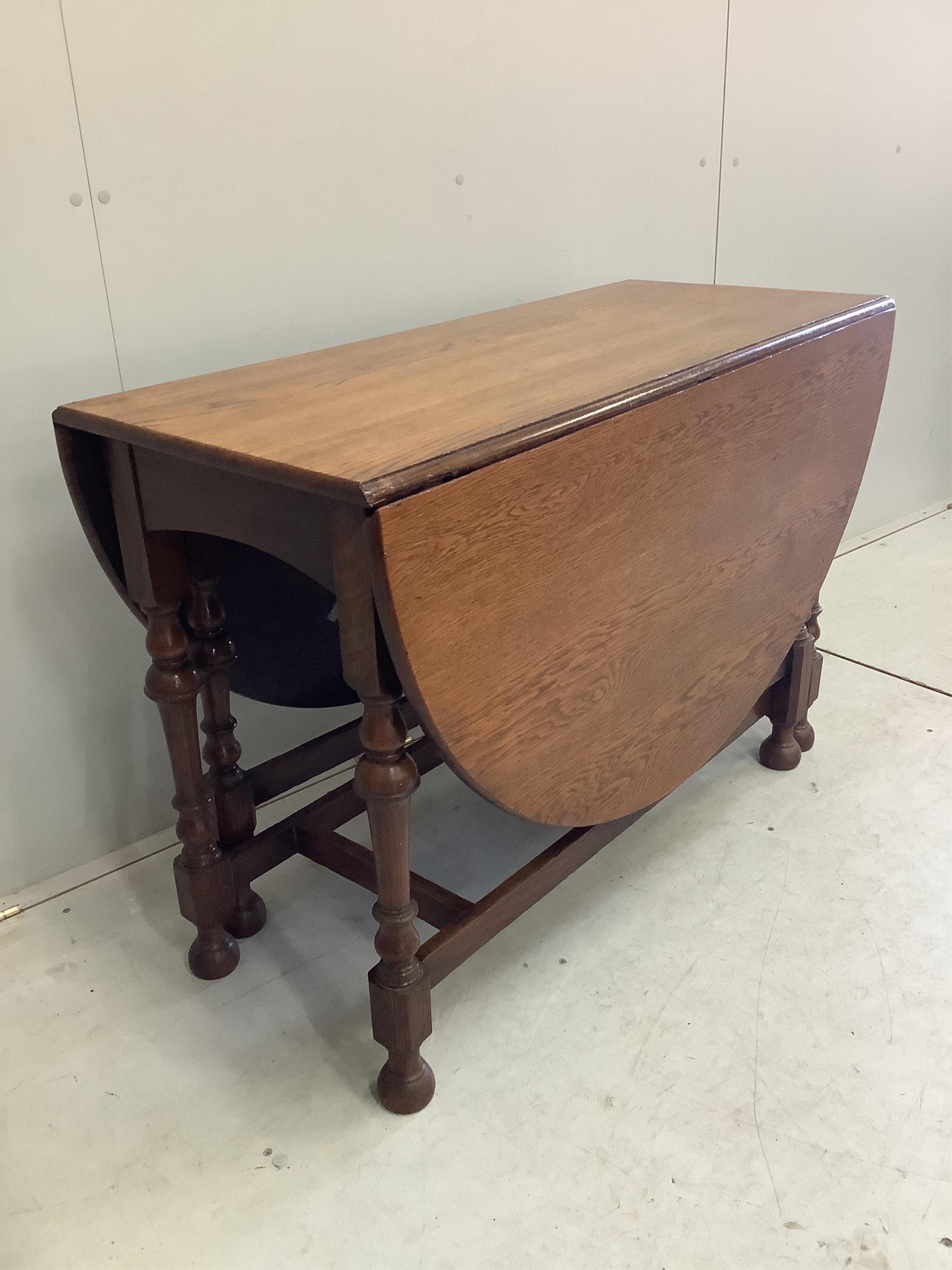 An early 20th century oak gateleg dining table, width 107cm, depth 47cm, height 74cm. Condition - fair to good